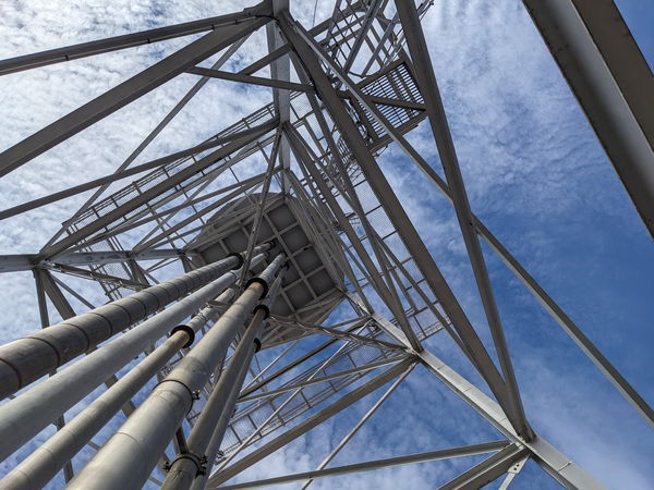 Looking up a steel lattice water tower against a blue sky