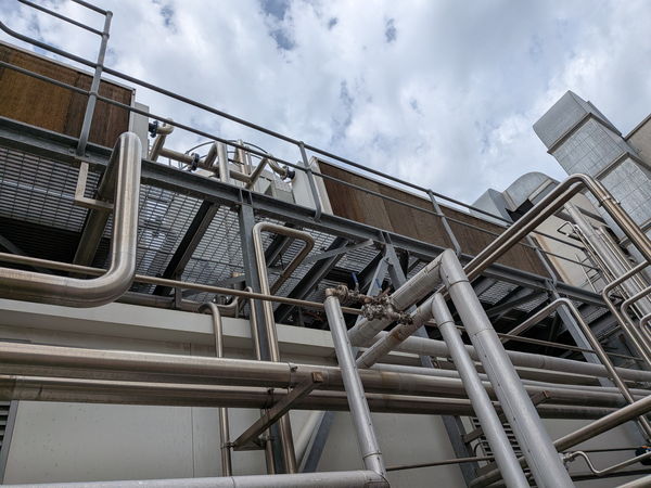 Stainless pipes against a clouded sky