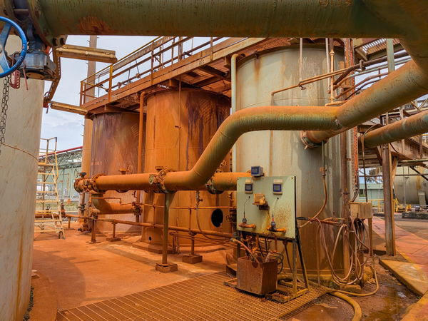 Rust-toned tanks and pipework at a process plant