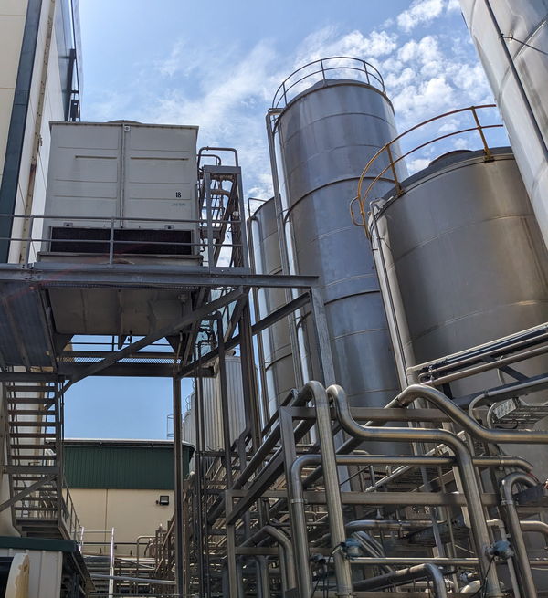 Silos and a cooling tower against a blue sky